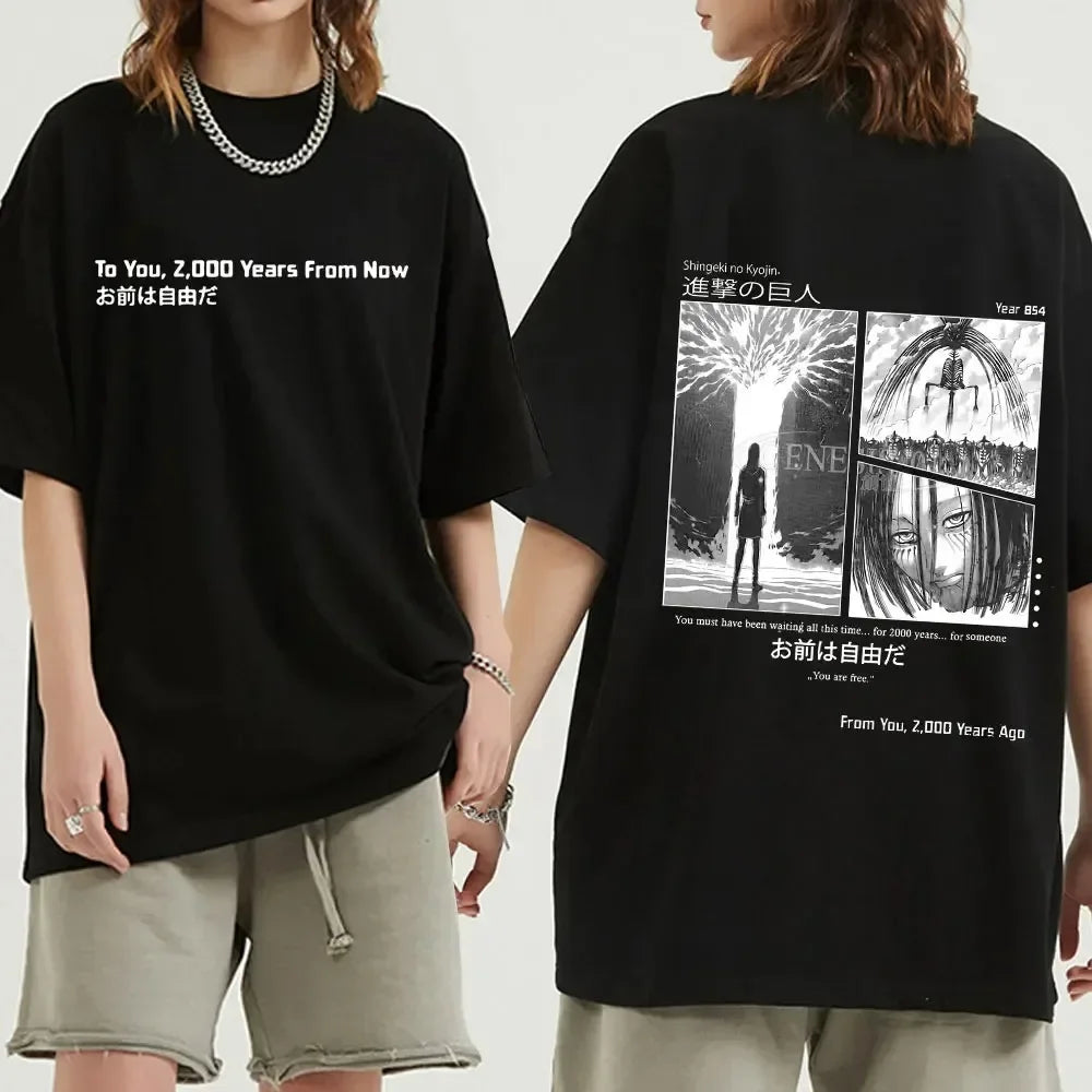 Black oversized Attack on Titan anime streetwear t-shirt with "To You, 2,000 Years From Now" text on the front and manga panel graphic of Eren and Ymir on the back, Japanese urban fashion style.